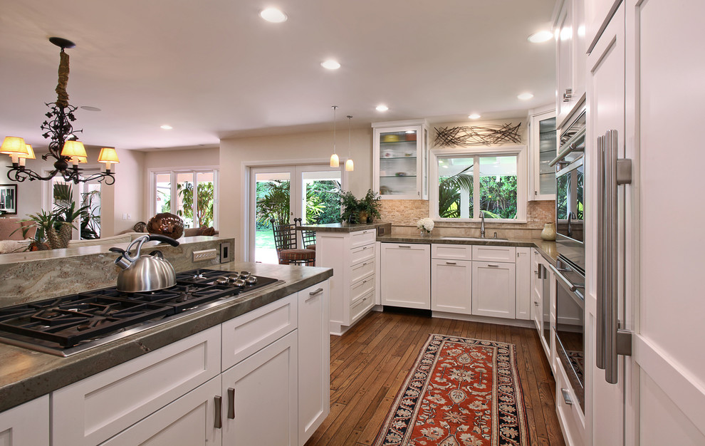 Exempel på ett klassiskt linjärt kök, med en dubbel diskho, skåp i shakerstil, vita skåp, granitbänkskiva, beige stänkskydd, stänkskydd i mosaik, rostfria vitvaror, en halv köksö och mellanmörkt trägolv