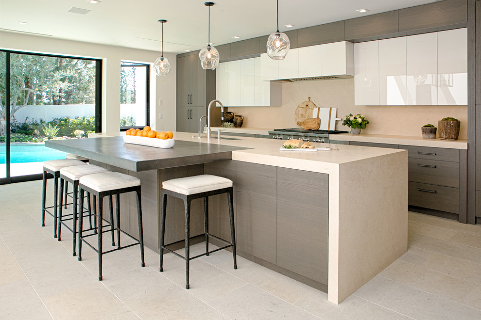 Inspiration for a contemporary galley beige floor eat-in kitchen remodel in Orange County with an undermount sink, flat-panel cabinets, medium tone wood cabinets, beige backsplash, stainless steel appliances, an island and beige countertops