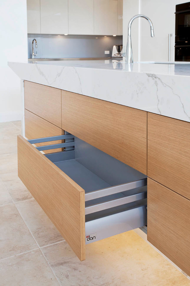 Inspiration for a large modern l-shaped limestone floor open concept kitchen remodel in Sydney with an undermount sink, flat-panel cabinets, white cabinets, quartz countertops, gray backsplash, mirror backsplash, black appliances and an island
