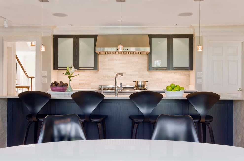 Bild på ett stort funkis vit linjärt vitt kök med öppen planlösning, med en undermonterad diskho, skåp i shakerstil, svarta skåp, bänkskiva i kvartsit, beige stänkskydd, stänkskydd i travertin, rostfria vitvaror, en köksö, ljust trägolv och brunt golv