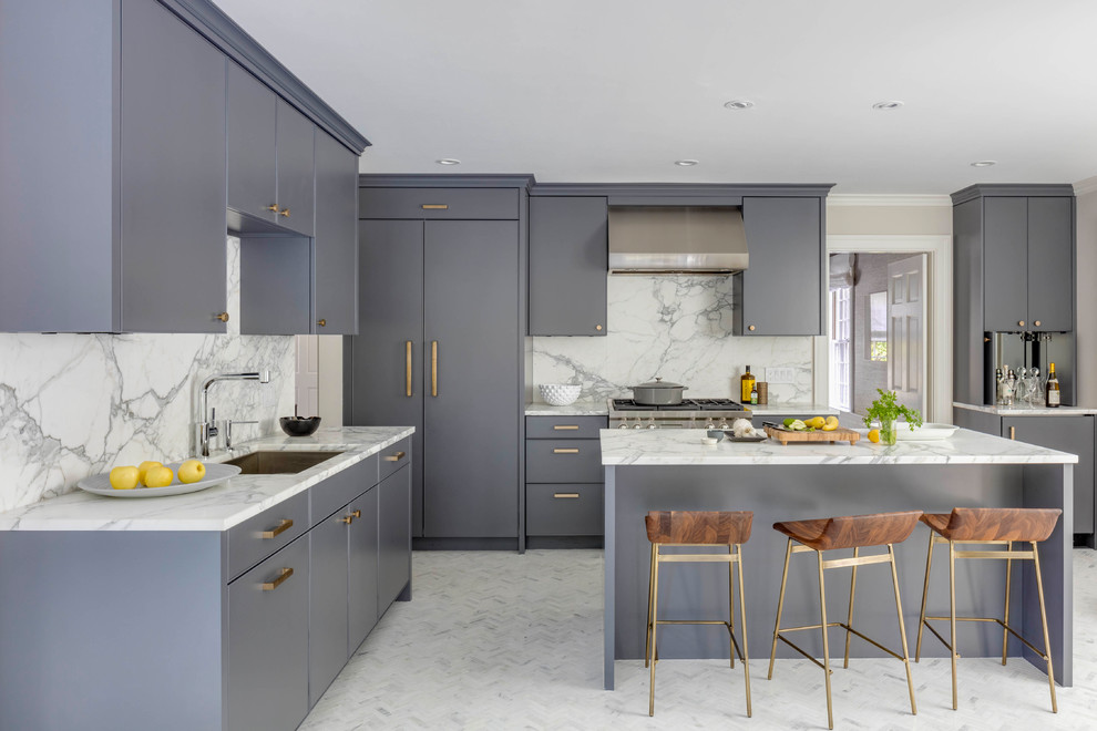 This is an example of a classic l-shaped kitchen/diner in Boston with a submerged sink, flat-panel cabinets, grey cabinets, white splashback, integrated appliances, an island, white floors and white worktops.