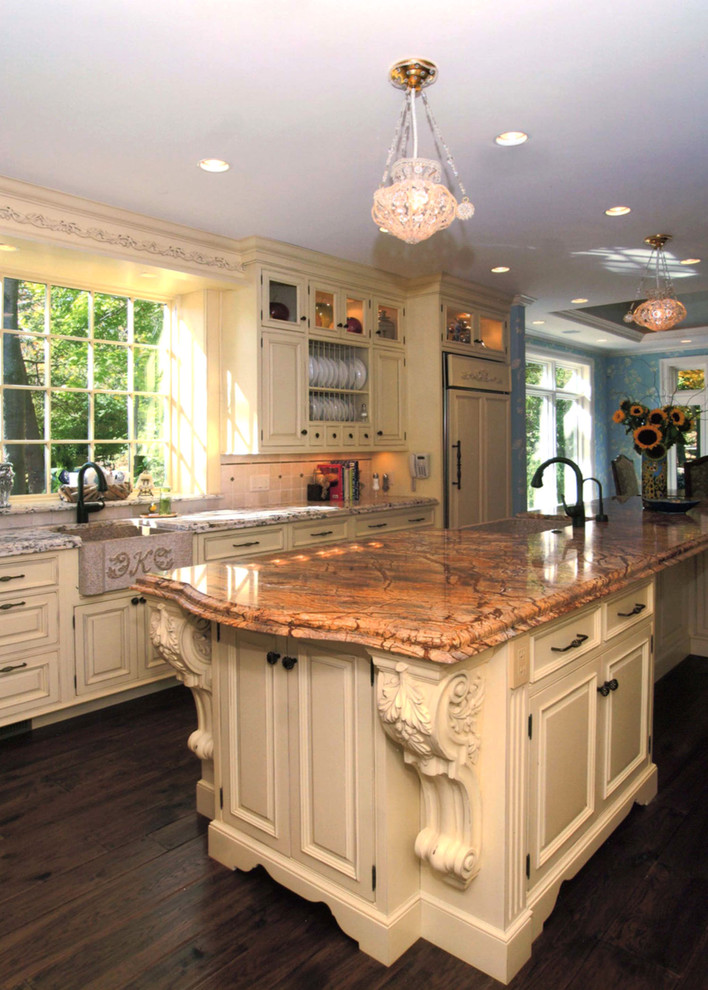 Eat-in kitchen - large traditional l-shaped dark wood floor and brown floor eat-in kitchen idea in Boston with a farmhouse sink, raised-panel cabinets, granite countertops, paneled appliances, beige cabinets, beige backsplash, ceramic backsplash and an island