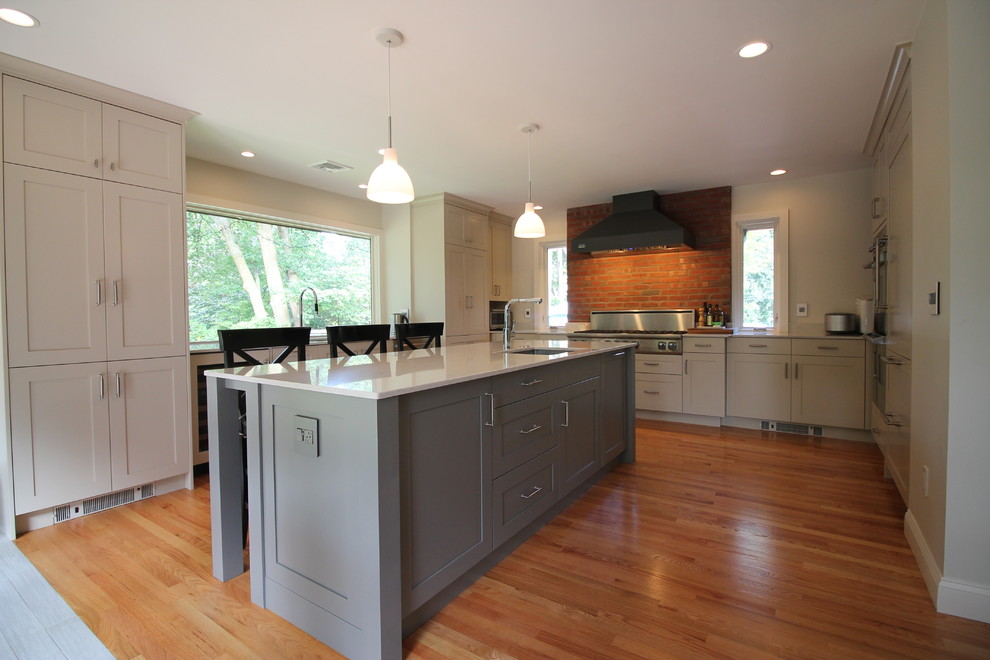 Example of a huge transitional u-shaped light wood floor kitchen design in Boston with an undermount sink, recessed-panel cabinets, gray cabinets, quartz countertops, stainless steel appliances and an island