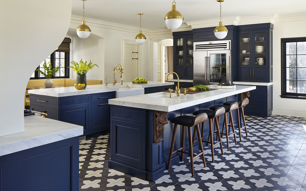ニューヨークにあるトランジショナルスタイルのおしゃれなキッチン (青いキャビネット、シルバーの調理設備、セラミックタイルの床、黒い床、白いキッチンカウンター、アンダーカウンターシンク、白いキッチンパネル、ライムストーンのキッチンパネル、シェーカースタイル扉のキャビネット) の写真