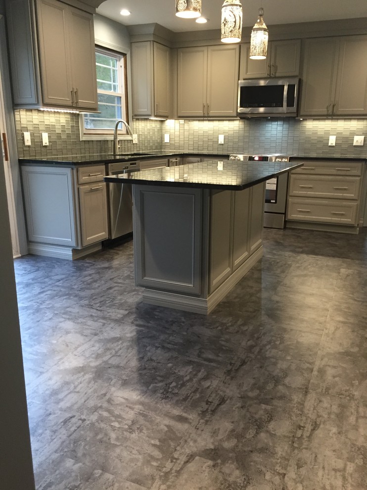 Inspiration for a mid-sized modern l-shaped vinyl floor eat-in kitchen remodel in New York with a single-bowl sink, shaker cabinets, gray cabinets, granite countertops, gray backsplash, glass sheet backsplash, stainless steel appliances and an island