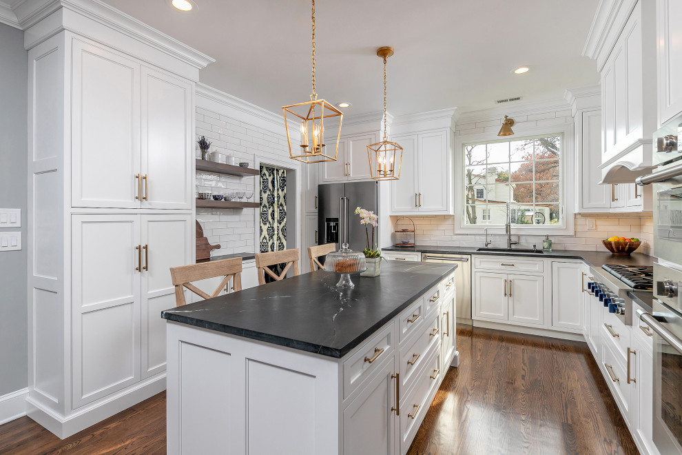 Example of a classic eat-in kitchen design in Philadelphia with an undermount sink, beaded inset cabinets, white cabinets, quartzite countertops, white backsplash, subway tile backsplash, stainless steel appliances, an island and black countertops