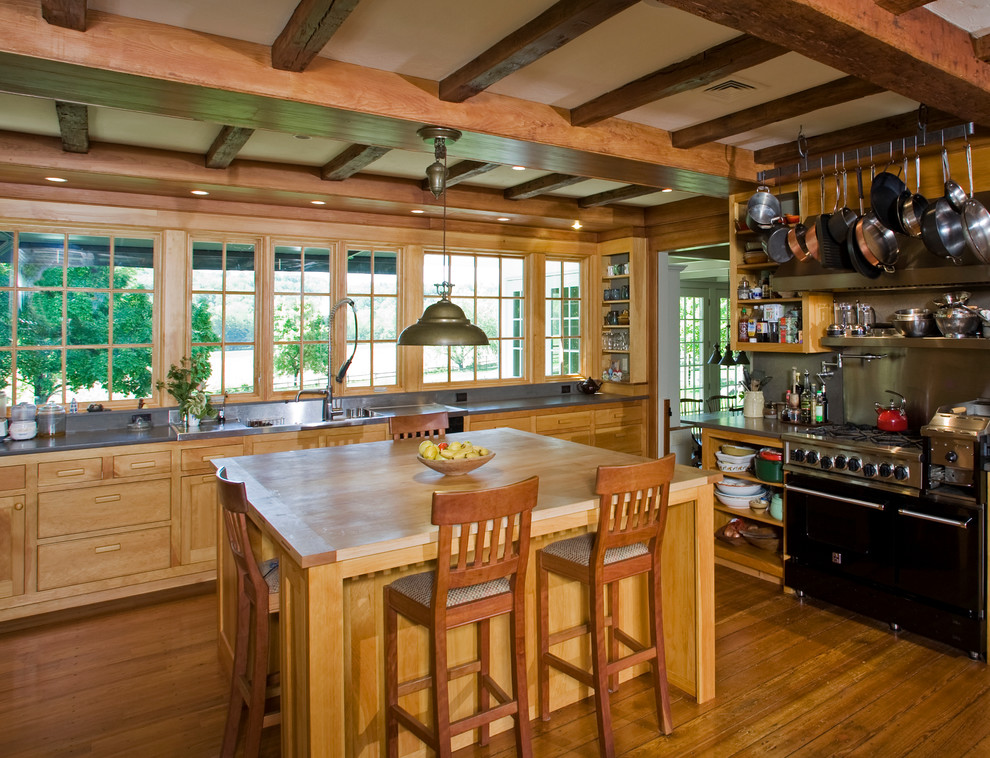 На фото: кухня в стиле рустика с деревянной столешницей, фасадами цвета дерева среднего тона и черной техникой