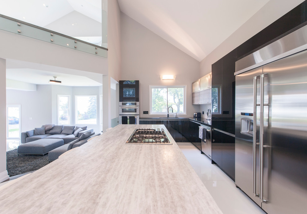 Inspiration for an expansive contemporary l-shaped kitchen/diner in Toronto with an island, flat-panel cabinets, black cabinets, granite worktops, stainless steel appliances and marble flooring.
