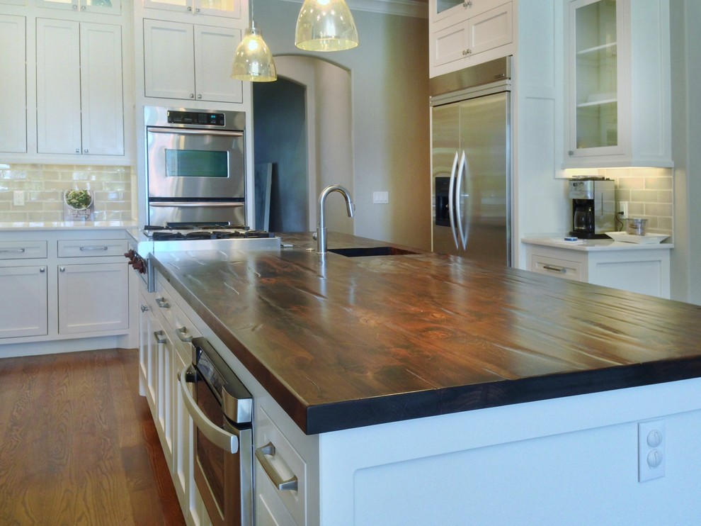 Inspiration for a mid-sized transitional l-shaped dark wood floor eat-in kitchen remodel in Oklahoma City with an undermount sink, white cabinets, subway tile backsplash, an island, marble countertops, recessed-panel cabinets, green backsplash and stainless steel appliances