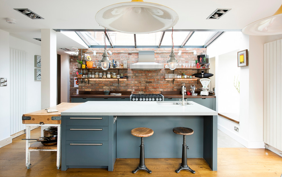 Foto på ett industriellt kök med öppen planlösning, med en dubbel diskho, öppna hyllor och flera köksöar