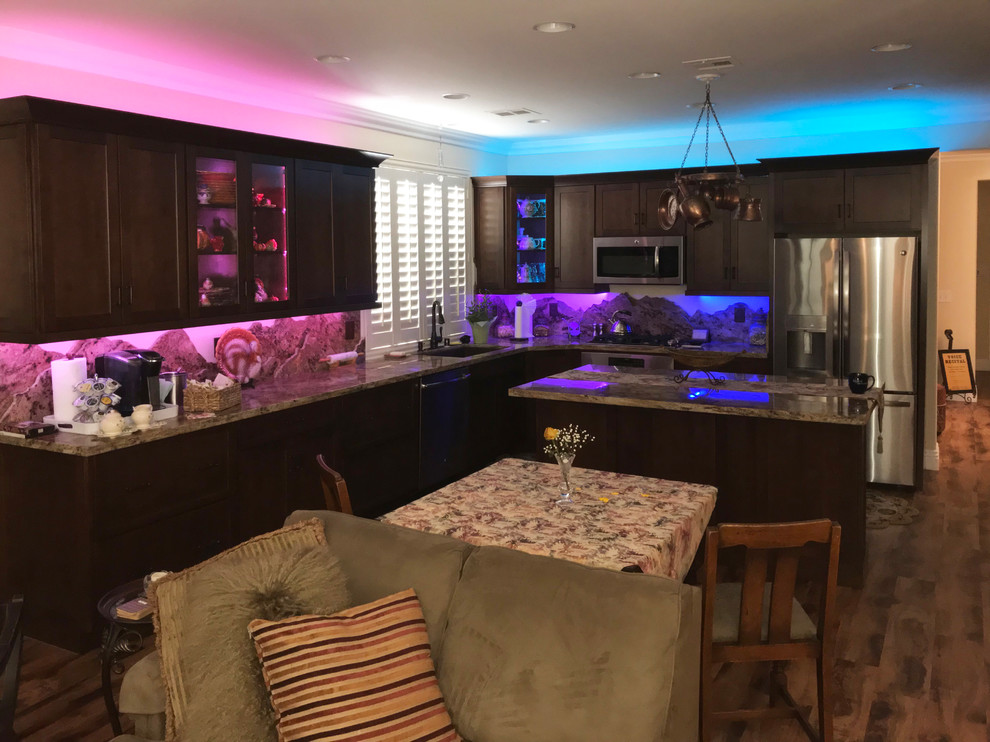 Bild på ett stort funkis flerfärgad flerfärgat kök, med skåp i mörkt trä, granitbänkskiva, flerfärgad stänkskydd, stänkskydd i sten, rostfria vitvaror, laminatgolv, en köksö och brunt golv