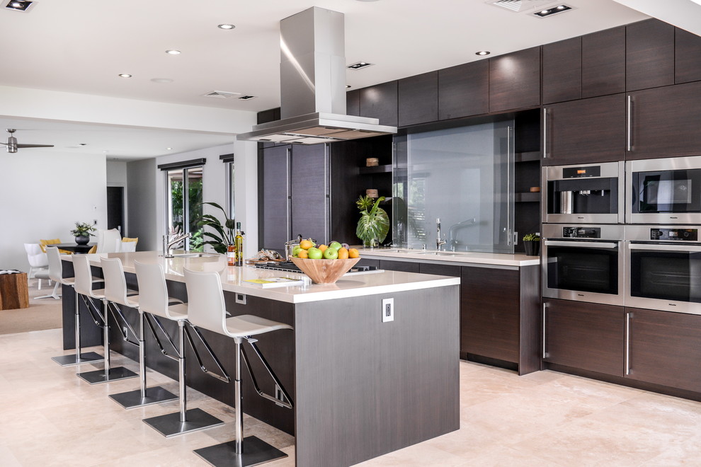 This is an example of a contemporary kitchen in Hawaii with flat-panel cabinets, dark wood cabinets, glass sheet splashback, stainless steel appliances and an island.