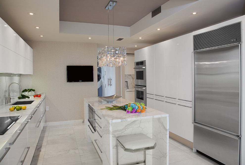 This is an example of a medium sized contemporary galley kitchen in New York with a submerged sink, flat-panel cabinets, white cabinets, marble worktops, white splashback, stone slab splashback and marble flooring.