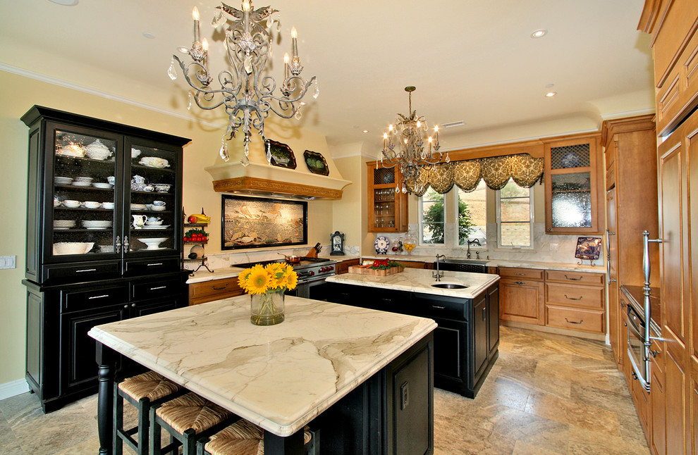 Example of a classic u-shaped kitchen design in San Diego with a farmhouse sink, marble countertops and two islands