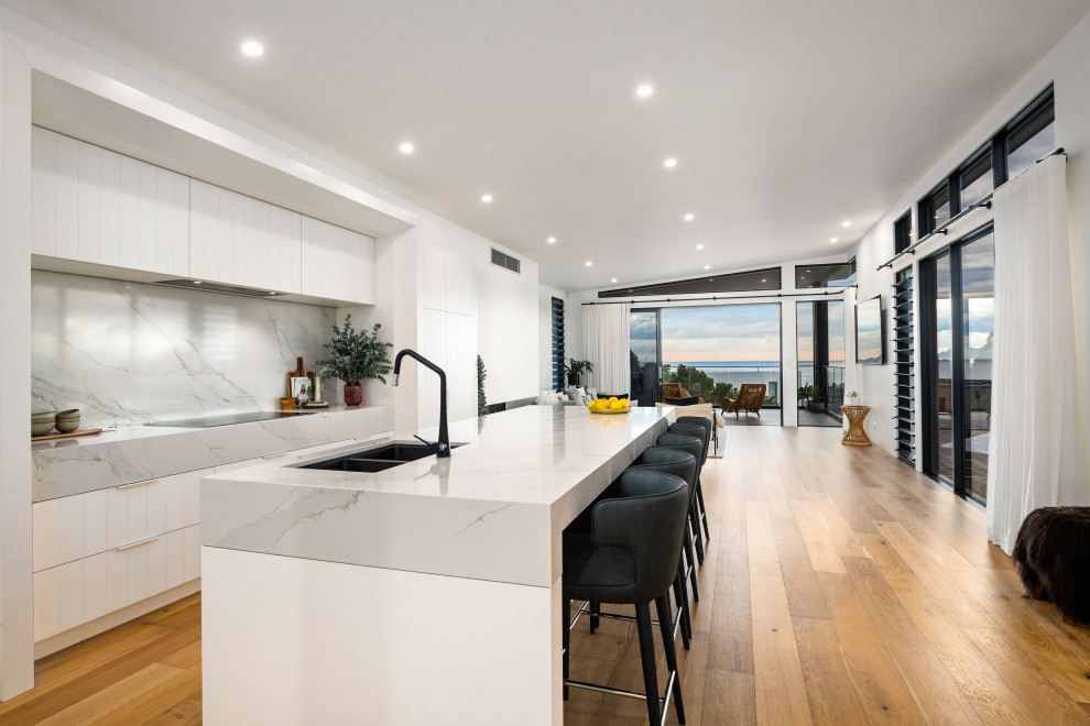 Offene, Zweizeilige, Mittelgroße Moderne Küche mit Schrankfronten im Shaker-Stil, weißen Schränken, Mineralwerkstoff-Arbeitsplatte und Kücheninsel in Wollongong