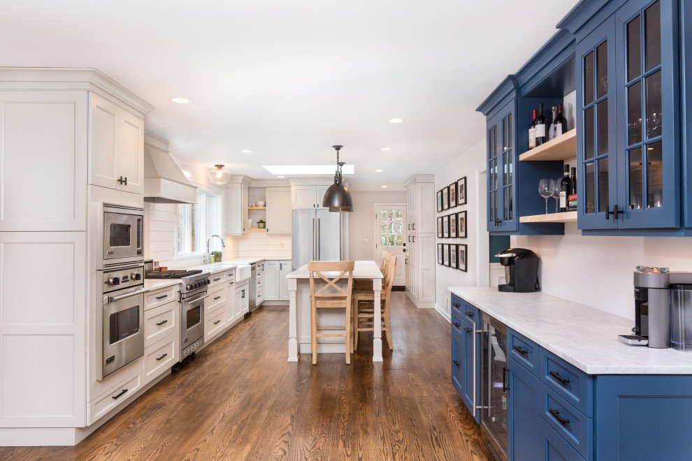 Exempel på ett stort lantligt vit vitt kök, med en rustik diskho, skåp i shakerstil, blå skåp, bänkskiva i kvarts, vitt stänkskydd, stänkskydd i trä, rostfria vitvaror, mellanmörkt trägolv, en köksö och brunt golv