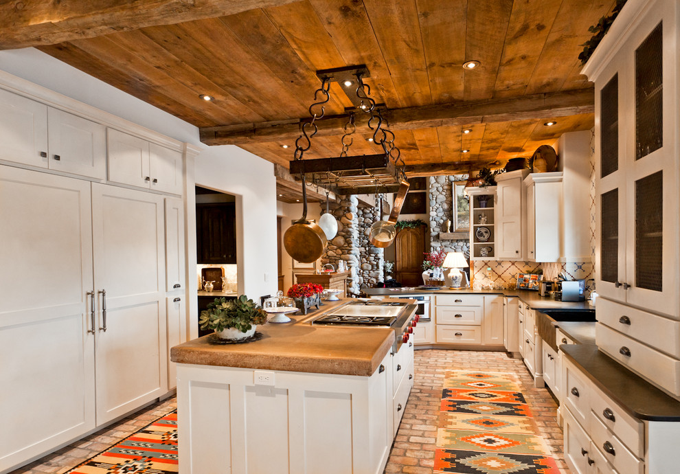 Foto på ett avskilt, mellanstort rustikt u-kök, med en rustik diskho, skåp i shakerstil, vita skåp, bänkskiva i koppar, flerfärgad stänkskydd, stänkskydd i mosaik, tegelgolv och en köksö