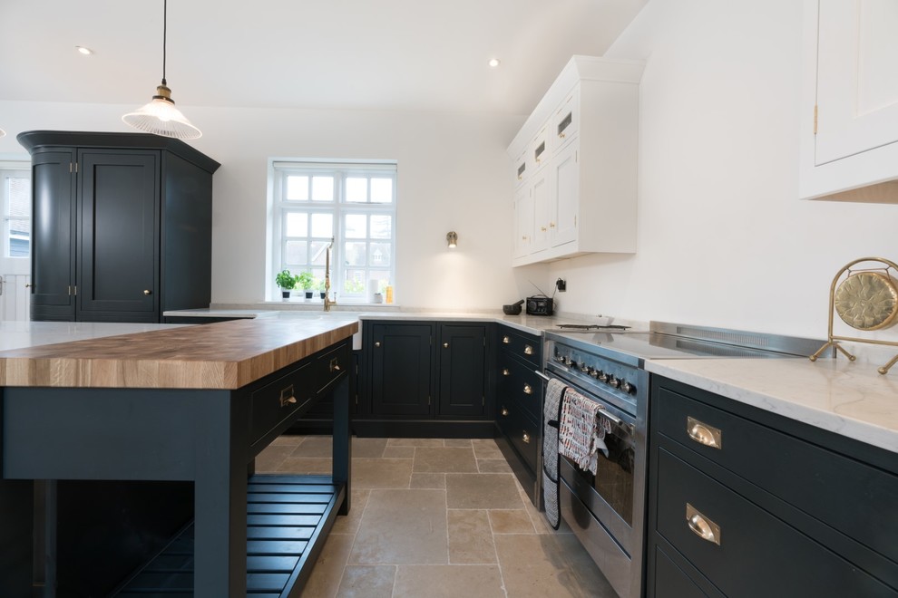 Design ideas for a large rural l-shaped kitchen/diner in Essex with a belfast sink, recessed-panel cabinets, blue cabinets, quartz worktops, stainless steel appliances, ceramic flooring, an island and beige floors.