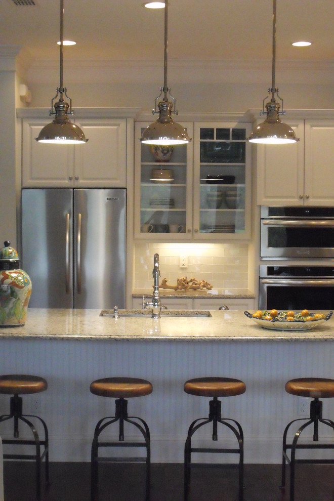 Offene Maritime Küche in U-Form mit Unterbauwaschbecken, profilierten Schrankfronten, türkisfarbenen Schränken, Granit-Arbeitsplatte, Küchenrückwand in Weiß, Rückwand aus Stäbchenfliesen und Küchengeräten aus Edelstahl in Jacksonville