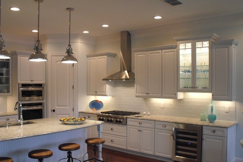 Example of a beach style u-shaped open concept kitchen design in Jacksonville with an undermount sink, raised-panel cabinets, turquoise cabinets, granite countertops, white backsplash, matchstick tile backsplash and stainless steel appliances
