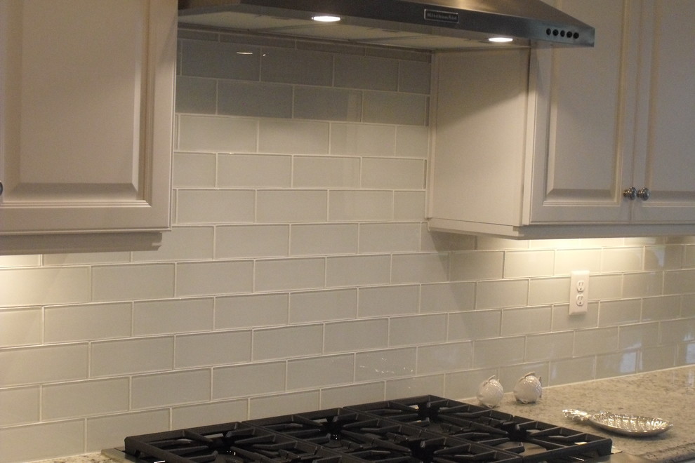 Maritim inredning av ett kök, med en undermonterad diskho, luckor med upphöjd panel, turkosa skåp, granitbänkskiva, vitt stänkskydd, stänkskydd i stickkakel och rostfria vitvaror