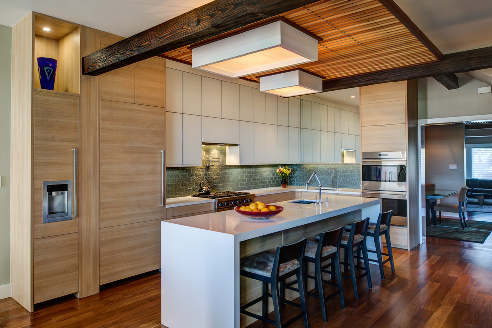 Foto di un cucina con isola centrale design con paraspruzzi grigio e elettrodomestici da incasso