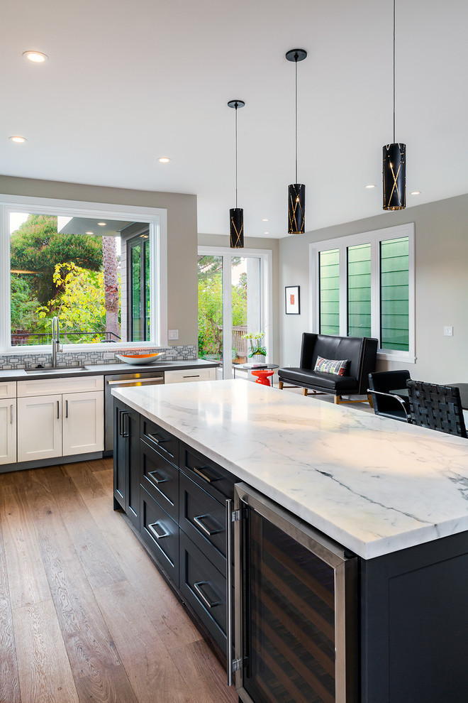 This is an example of a medium sized contemporary l-shaped open plan kitchen in San Francisco with a submerged sink, recessed-panel cabinets, dark wood cabinets, marble worktops, ceramic splashback, stainless steel appliances, medium hardwood flooring and an island.