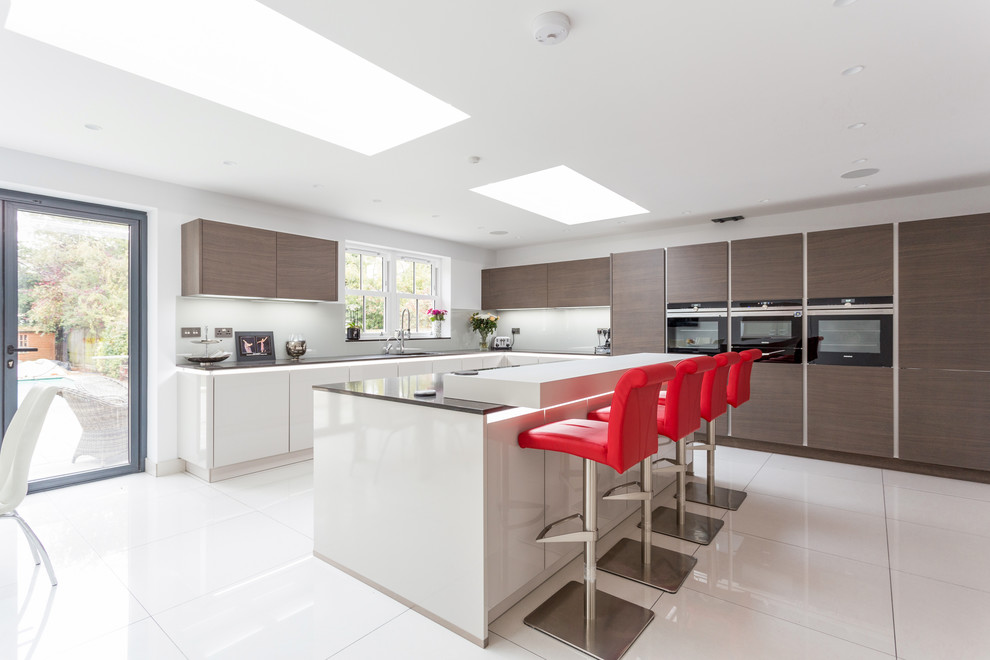 Design ideas for a large l-shaped open plan kitchen in London with glass-front cabinets, dark wood cabinets, granite worktops, grey splashback, glass sheet splashback and an island.