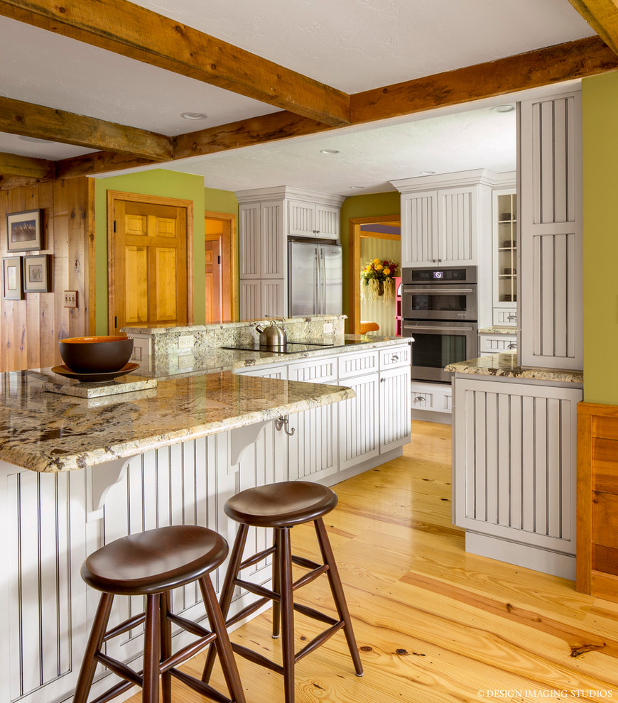 Example of a large eclectic light wood floor eat-in kitchen design in Boston with a farmhouse sink, louvered cabinets, white cabinets, granite countertops, beige backsplash, ceramic backsplash, stainless steel appliances and an island