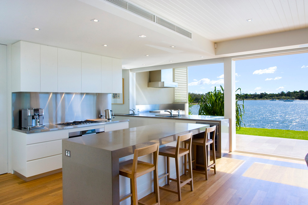 Moderne Küche mit flächenbündigen Schrankfronten, weißen Schränken und Küchenrückwand in Metallic in Sunshine Coast