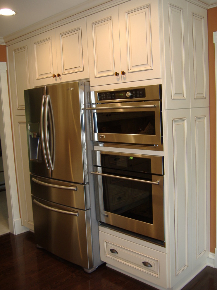 Foto de cocina clásica con fregadero sobremueble, armarios con paneles con relieve, puertas de armario blancas, encimera de cuarzo compacto y electrodomésticos de acero inoxidable