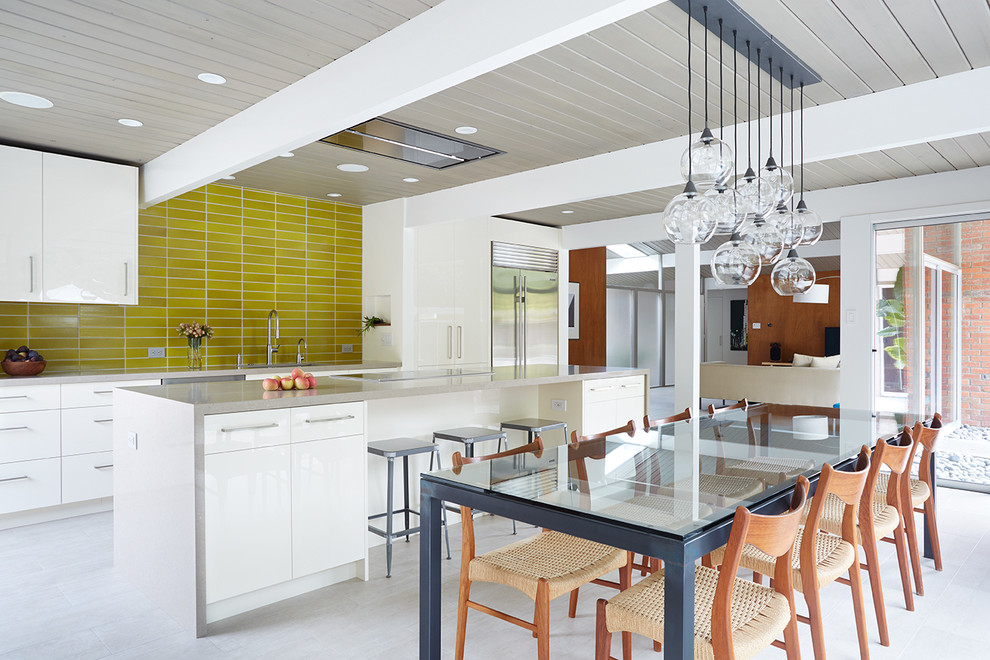 Open concept kitchen - 1950s galley open concept kitchen idea in San Francisco with white cabinets, yellow backsplash and an island