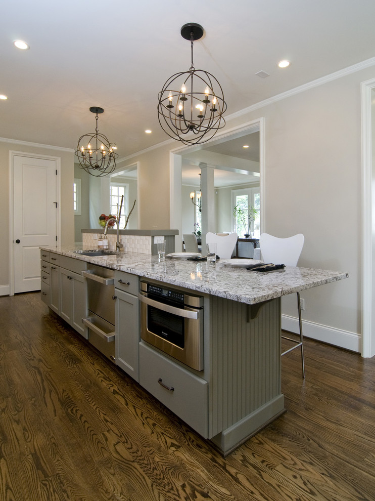 Inspiration for a large transitional u-shaped medium tone wood floor and brown floor kitchen remodel in Raleigh with an undermount sink, recessed-panel cabinets, white cabinets, granite countertops, white backsplash, subway tile backsplash, stainless steel appliances and an island