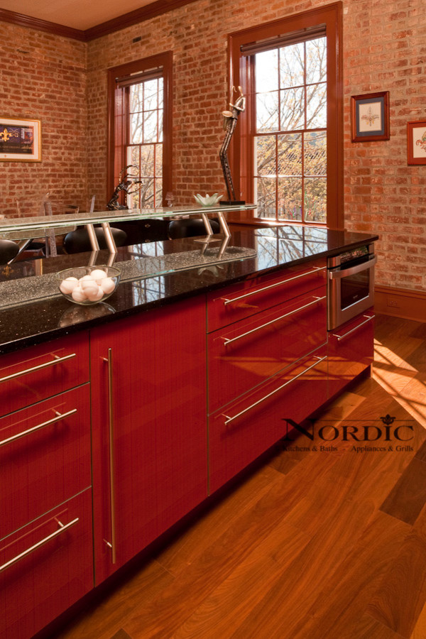 Exempel på ett mellanstort modernt linjärt kök och matrum, med en undermonterad diskho, släta luckor, röda skåp, granitbänkskiva, integrerade vitvaror, beige stänkskydd, stänkskydd i glaskakel, mörkt trägolv och en köksö