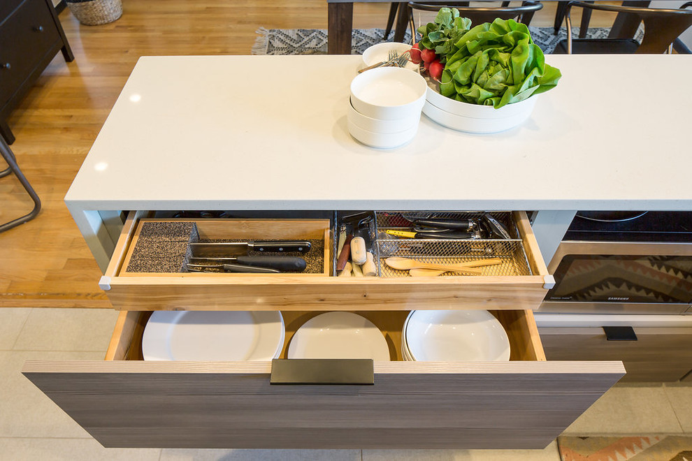 Eat-in kitchen - mid-sized 1950s u-shaped porcelain tile and beige floor eat-in kitchen idea in Seattle with an undermount sink, flat-panel cabinets, medium tone wood cabinets, quartz countertops, beige backsplash, ceramic backsplash, stainless steel appliances and a peninsula
