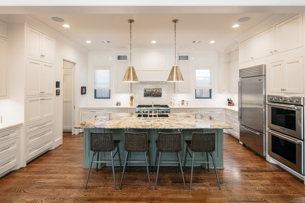 Kitchen - transitional u-shaped dark wood floor and brown floor kitchen idea in Houston with an undermount sink, shaker cabinets, white cabinets, white backsplash, subway tile backsplash, stainless steel appliances, an island and white countertops