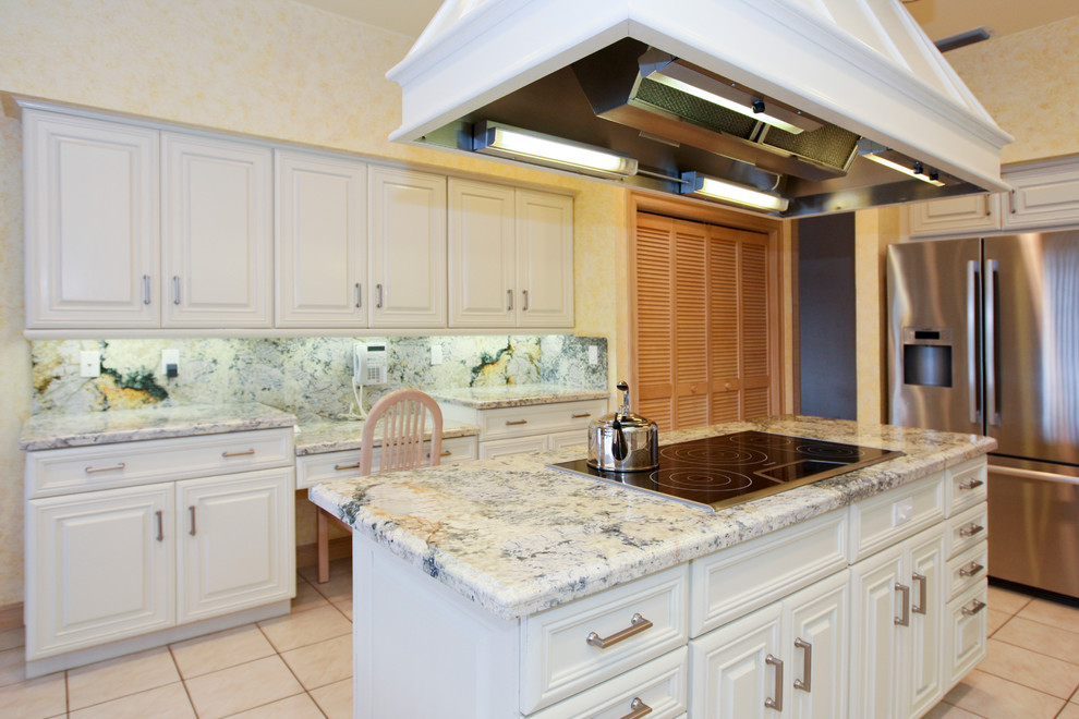 Foto på ett stort vintage kök, med en dubbel diskho, luckor med upphöjd panel, vita skåp, granitbänkskiva, flerfärgad stänkskydd, stänkskydd i sten, rostfria vitvaror, en köksö och klinkergolv i keramik