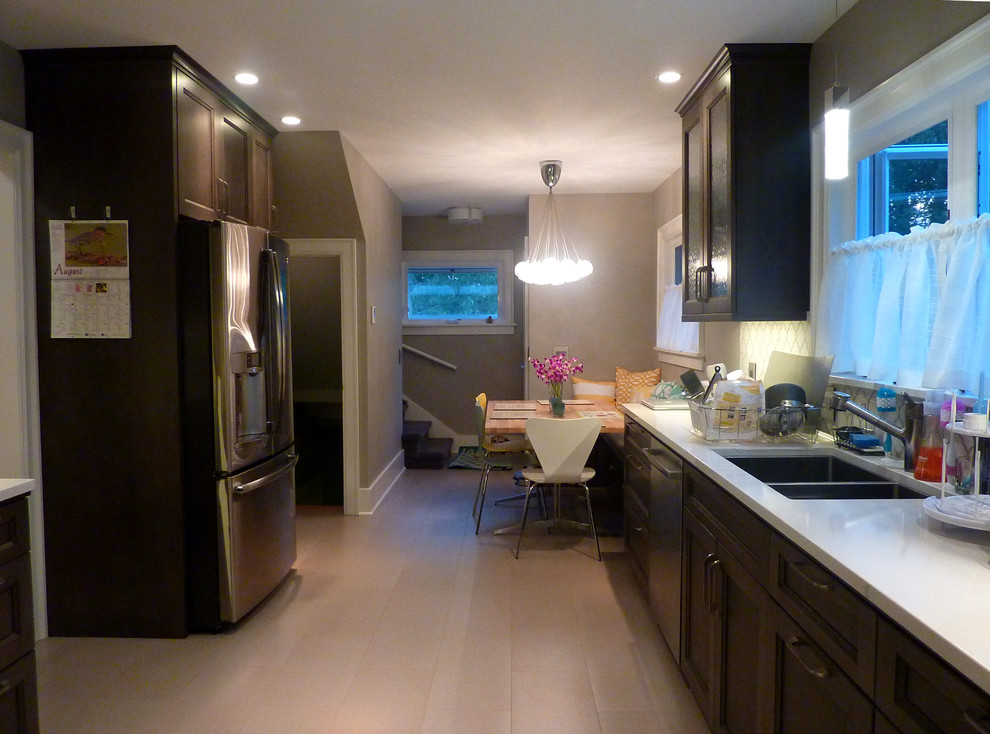 Bild på ett mellanstort funkis kök, med en nedsänkt diskho, luckor med infälld panel, skåp i mörkt trä, flerfärgad stänkskydd, rostfria vitvaror, klinkergolv i porslin, bänkskiva i kvarts och stänkskydd i keramik