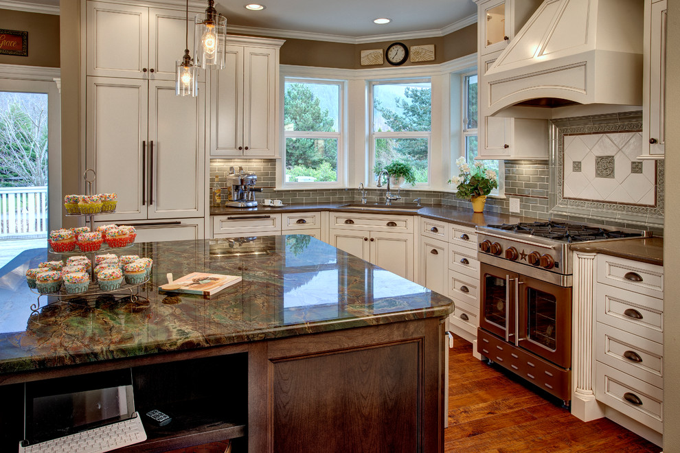 Inspiration for a timeless u-shaped eat-in kitchen remodel in Seattle with an undermount sink, recessed-panel cabinets, white cabinets, granite countertops, green backsplash, subway tile backsplash and paneled appliances