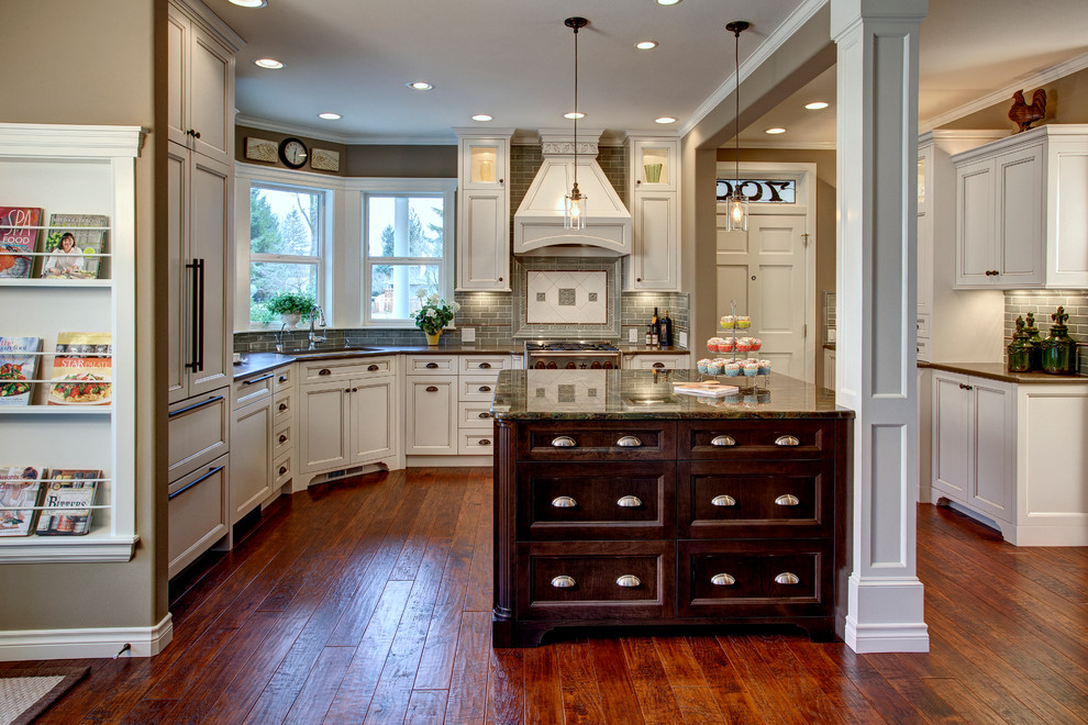 Classic u-shaped kitchen/diner in Seattle with recessed-panel cabinets, white cabinets, granite worktops, metro tiled splashback, integrated appliances, a submerged sink and green splashback.