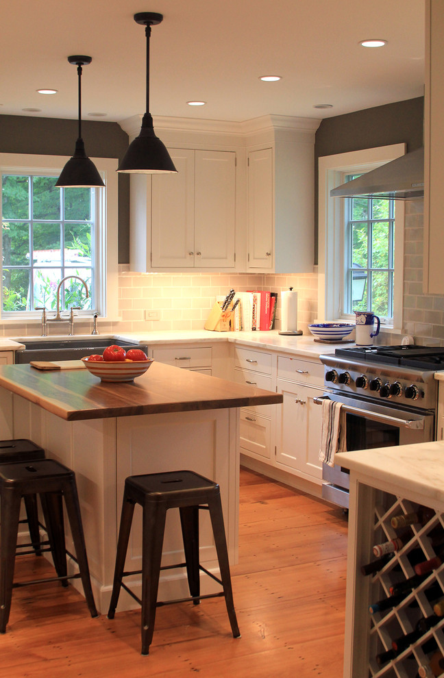 Exempel på ett avskilt, mellanstort lantligt u-kök, med en rustik diskho, skåp i shakerstil, vita skåp, marmorbänkskiva, grått stänkskydd, stänkskydd i tunnelbanekakel, rostfria vitvaror, ljust trägolv och en köksö