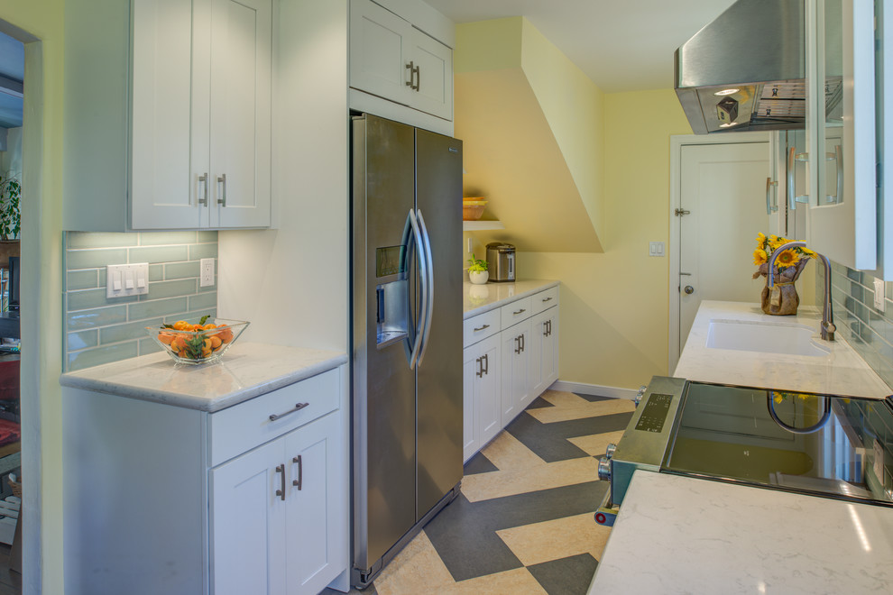 This is an example of a small traditional galley enclosed kitchen in San Francisco with a single-bowl sink, shaker cabinets, white cabinets, engineered stone countertops, blue splashback, ceramic splashback, stainless steel appliances, lino flooring and no island.