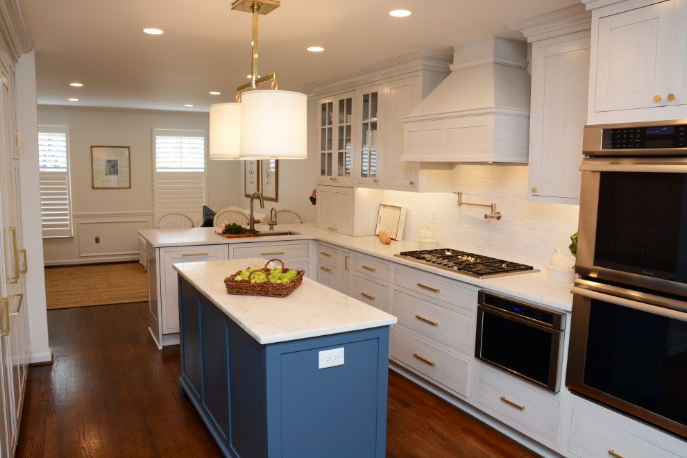 Foto på ett avskilt, mellanstort vit l-kök, med en enkel diskho, luckor med infälld panel, vita skåp, marmorbänkskiva, vitt stänkskydd, stänkskydd i tunnelbanekakel, rostfria vitvaror, mörkt trägolv, en halv köksö och brunt golv
