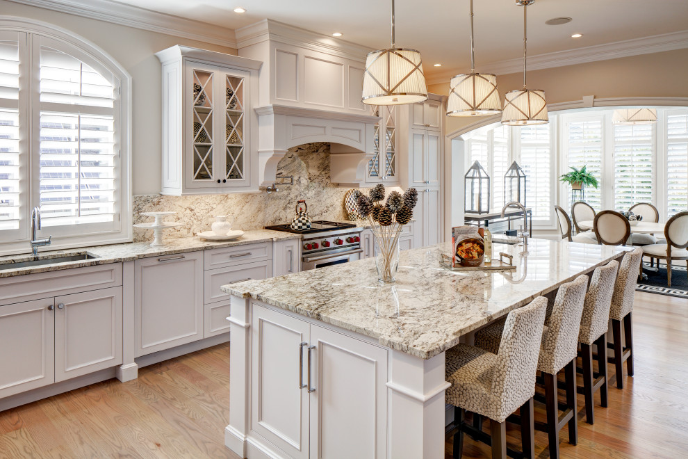Inspiration for a transitional u-shaped medium tone wood floor and brown floor eat-in kitchen remodel in DC Metro with an undermount sink, recessed-panel cabinets, white cabinets, multicolored backsplash, paneled appliances, an island and multicolored countertops