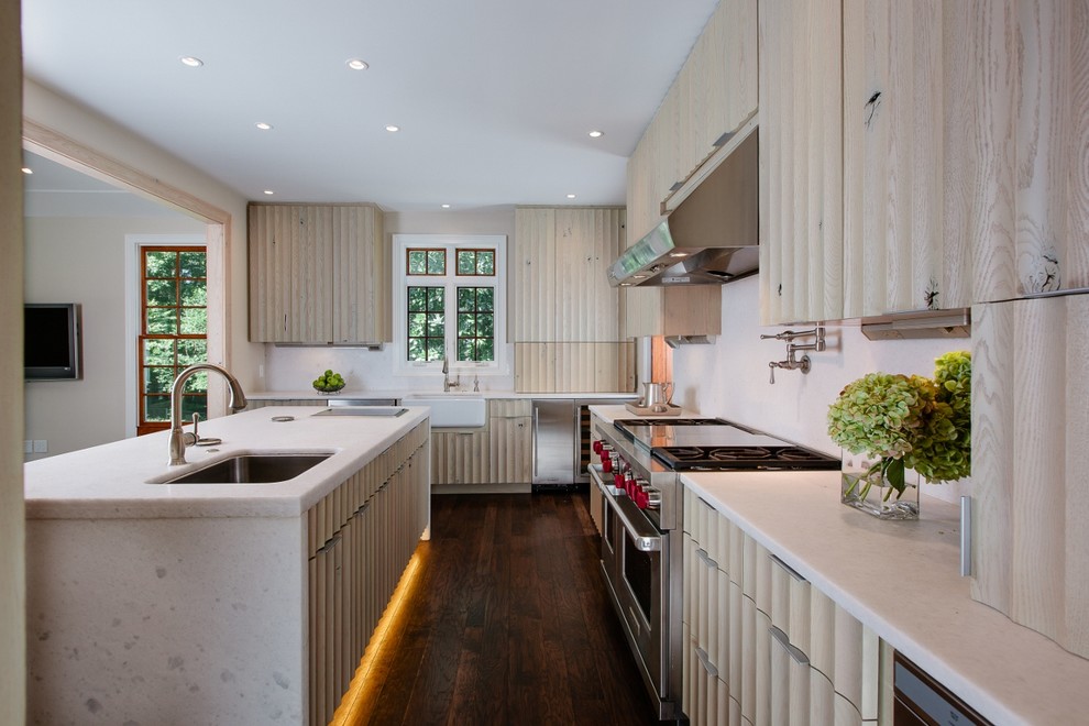Design ideas for a medium sized traditional l-shaped kitchen in Atlanta with a belfast sink, light wood cabinets, white splashback, stainless steel appliances, dark hardwood flooring and an island.