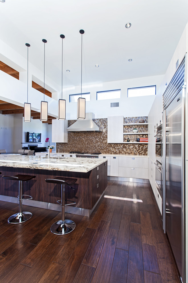 Modelo de cocina contemporánea con armarios con paneles lisos, puertas de armario blancas y electrodomésticos de acero inoxidable