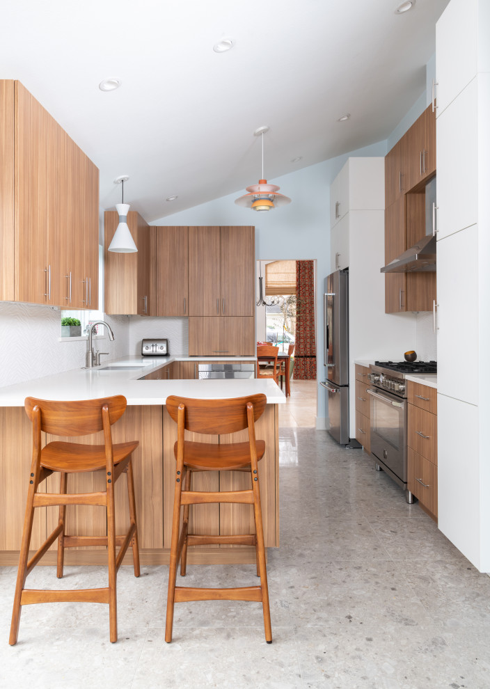Idéer för att renovera ett mellanstort funkis vit vitt kök, med en undermonterad diskho, släta luckor, skåp i mellenmörkt trä, bänkskiva i kvarts, vitt stänkskydd, stänkskydd i porslinskakel, rostfria vitvaror, terrazzogolv, en halv köksö och grått golv
