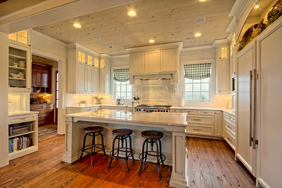 Foto på ett avskilt, stort rustikt u-kök, med en rustik diskho, luckor med infälld panel, vita skåp, marmorbänkskiva, flerfärgad stänkskydd, stänkskydd i mosaik, integrerade vitvaror, mellanmörkt trägolv, en köksö och brunt golv