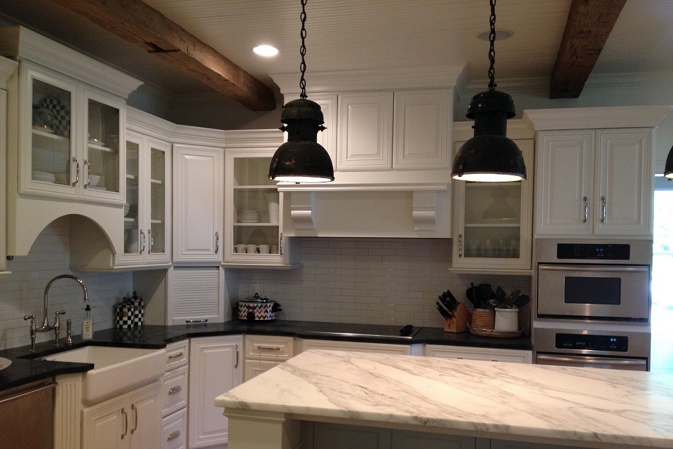 Exempel på ett stort amerikanskt kök, med en rustik diskho, luckor med upphöjd panel, vita skåp, bänkskiva i täljsten, vitt stänkskydd, stänkskydd i tunnelbanekakel, rostfria vitvaror, ljust trägolv och en köksö