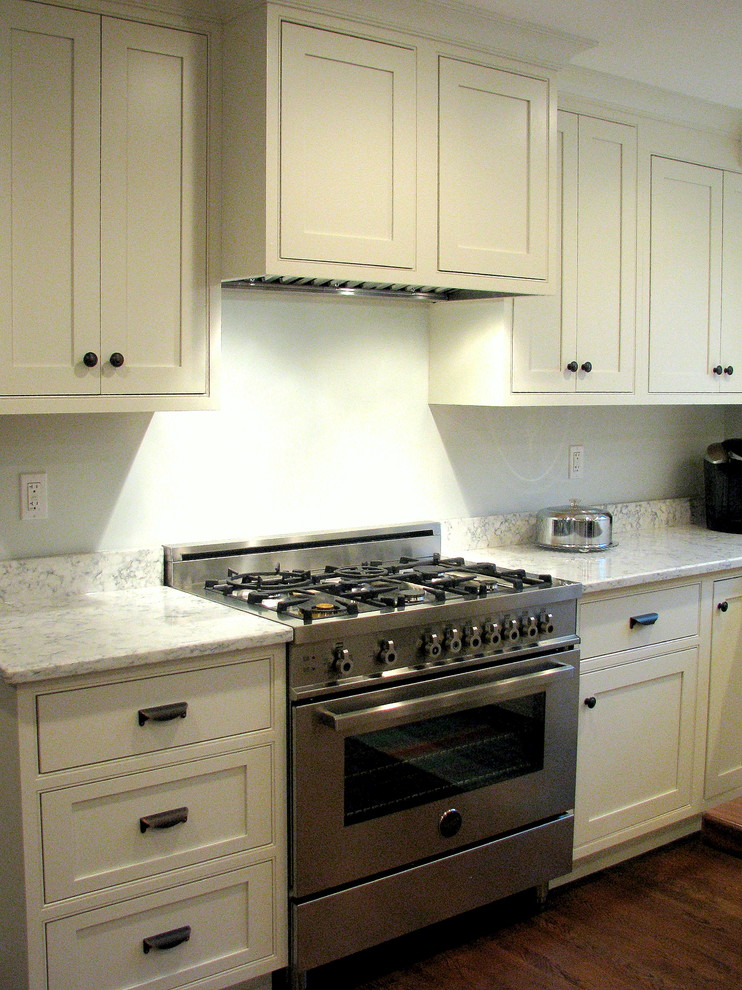 Exempel på ett mellanstort klassiskt kök, med en rustik diskho, luckor med profilerade fronter, vita skåp, bänkskiva i kvarts, vitt stänkskydd, rostfria vitvaror, mörkt trägolv och en köksö